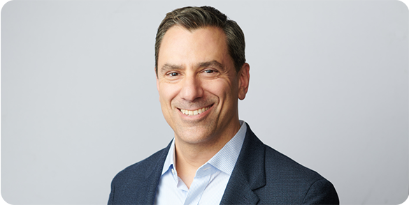 Portrait of Joe Sawyer smiling in a suit